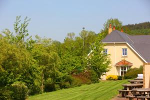 a house with picnic tables in front of it at Faithlegg Self Catering Mews in Waterford