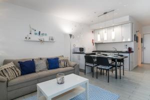 een woonkamer met een bank en een tafel bij Serenity by the Marina, Vilamoura in Quarteira