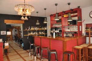 a bar in a restaurant with red walls and stools at Le Relais des Lacs in Planchez