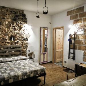 a bedroom with a bed and a stone wall at B&B Polvere di stelle in Ummari
