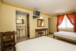 ein Hotelzimmer mit 2 Betten und einem Waschbecken in der Unterkunft OYO Hotel La Glorieta ,Huichapan ,Balneario Camino Real in Huichapan