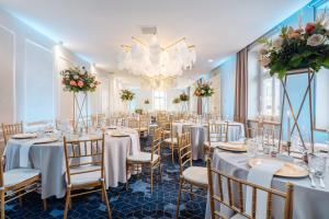 a banquet room with tables and chairs and a chandelier at Hotel Apis in Krakow