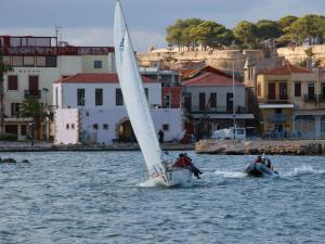 dos personas en un velero en el agua en Faros Rooms & Suites, en Rethymno
