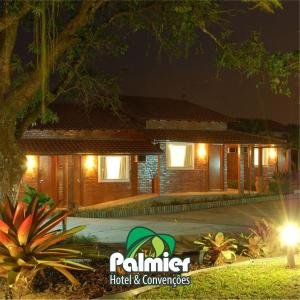una casa por la noche con luces delante de ella en Palmier Hotel & Convenções en Itaboraí