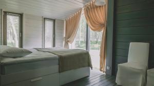 a bedroom with a bed and a large window at Edimonovo Village in Yedimonovo