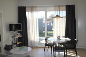 a living room with a table and chairs and a window at Tofta Resort in Tofta