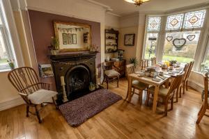 a dining room with a table and a fireplace at Craiglands Bed and Breakfast, Grassington in Grassington