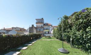 un jardín con césped frente a algunos edificios en BmyGuest - Almada Garden Apartment, en Oporto