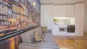 sala de estar con sofá y cocina en BmyGuest - Almada Garden Apartment, en Oporto