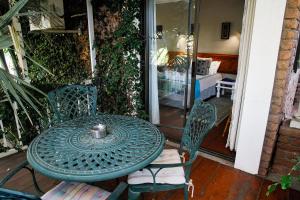 a green table and chairs on a patio at Ikaia River Lodge in Keimoes