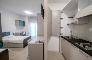 kuchnia i sypialnia z łóżkiem w pokoju w obiekcie SPH Hotel w Turynie