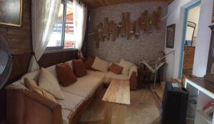 uma sala de estar com um sofá e uma parede de tijolos em Mamas Summer House em Larnaka