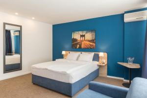 um quarto com uma cama e uma parede azul em Premium Crown Suites em Belgrado