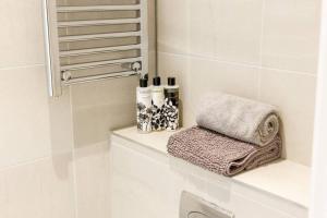 a bathroom with a towel sitting on a shelf at Stylish 2 bed 2 bath *Close To Beach and Centre with parking* in Bournemouth