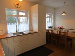 a kitchen with a sink and a table with chairs at Stafholtsey in Borgarnes