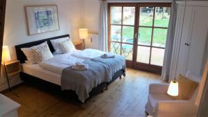 1 dormitorio con 1 cama, 1 silla y 1 ventana en Ferienhof Trapp en Ellringen