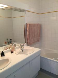 een badkamer met 2 wastafels en een bad bij Appartement Wimereux - Opaalkust met frontaal zeezicht in Wimereux