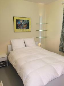 een slaapkamer met een groot wit bed. bij Appartement Wimereux - Opaalkust met frontaal zeezicht in Wimereux