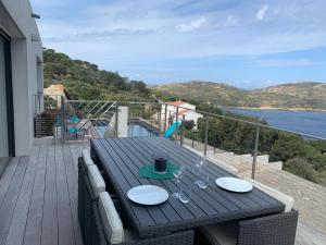 stół na balkonie z widokiem na wodę w obiekcie Villa MAKELE w Calvi