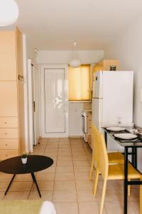 a kitchen with a table and a white refrigerator at Best House, Nirvana II, Patra in Patra