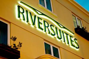 a neon sign on the side of a yellow building at Riversuites in Coimbra