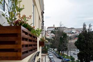 a balcony with a view of a city street with cars at Riversuites in Coimbra