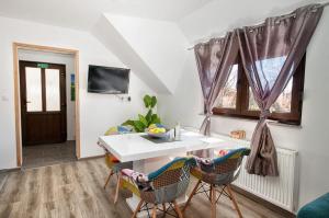 a dining room with a white table and chairs at Apartments Escape in Drežnik Grad