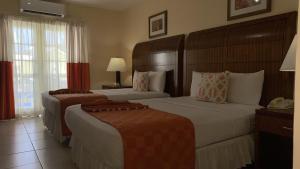 a hotel room with two beds and a telephone at Bay Gardens Inn in Gros Islet