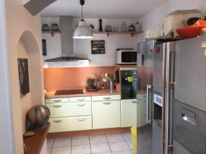 a kitchen with white cabinets and a stainless steel refrigerator at La Milhaud in Milhaud
