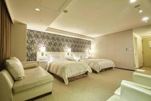 a hotel room with two beds and a couch at Family Hotel Taipei in Zhonghe