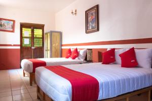 サカテカスにあるOYO Hotel Meson de la Concepcionの赤と白の部屋のベッド2台