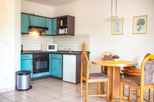 uma cozinha com armários azuis e uma mesa com cadeiras em Ferienwohnung Sewenig em Müden