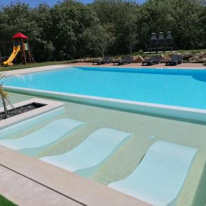 a swimming pool with a slide and a playground at PÉROLA d'ÓBIDOS T3 in Gaieiras