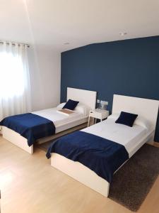 2 camas en un dormitorio con paredes azules en Iberflat Villa Tramontana, en Benicàssim