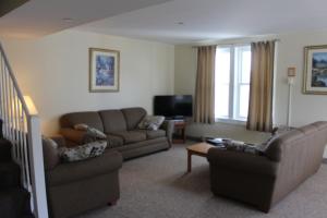 a living room with two couches and a tv at Town Square Condominiums in Waterville Valley