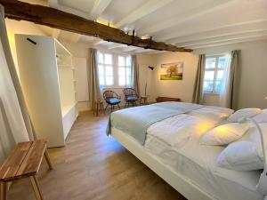 um quarto com uma cama grande e piso em madeira em Monschau-Auszeit: Historisch wohnen direkt am Bach em Monschau