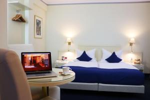 a hotel room with a bed and a laptop on a table at Hotel Dalberg in Aschaffenburg