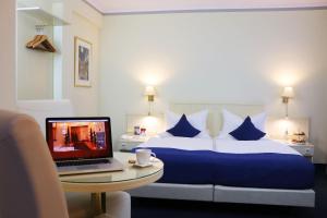 a hotel room with a bed and a laptop on a table at Hotel Dalberg in Aschaffenburg