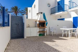 un edificio blanco con mesa, mesa y sillas en Blue Villa by ALGARVEMANTA en Manta Rota