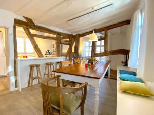 a kitchen and dining room with a wooden table and chairs at Monschau-Auszeit: Historisch wohnen direkt am Bach in Monschau
