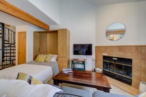 uma sala de estar com 2 camas e uma lareira em Ski-in Condo - Hot Tub - Pool - Gym - Breckenridge em Breckenridge