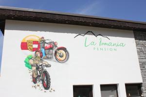 a mural of a motorcycle on the side of a building at La Irmania Pension in Ledenitzen
