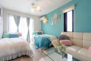 東京にあるAsakusa Sky Stay Tiffany blue Roomのベッド2台とソファのあるリビングルーム