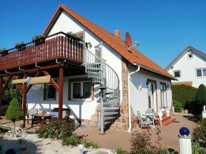 a white house with a staircase and a patio at Apartment Natali in Öhringen