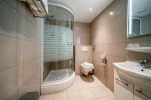 uma casa de banho com um chuveiro, um WC e um lavatório. em Hotel Iron Horse Amsterdam em Amesterdão