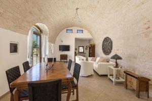 a dining room with a table and a living room at Antica Tenuta dei Trulli in Alberobello