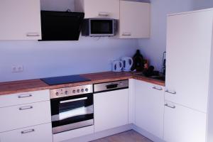 a kitchen with white cabinets and a stove top oven at Appartements Bleistattblick in Steindorf am Ossiacher See