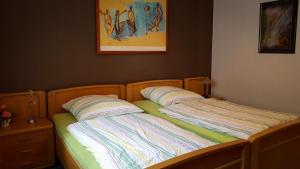 ein Bett mit zwei Kissen darauf in einem Schlafzimmer in der Unterkunft Ferienwohnung Reuscher, Trier-Newel in Newel