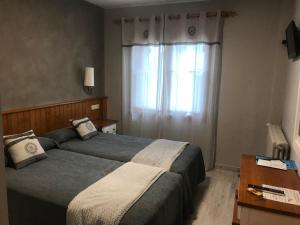 - une chambre avec 2 lits et une fenêtre dans l'établissement Hotel Casa Morlans, à Panticosa