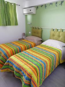two beds with colorful blankets in a room at Alba Marina Rooms in Tollo